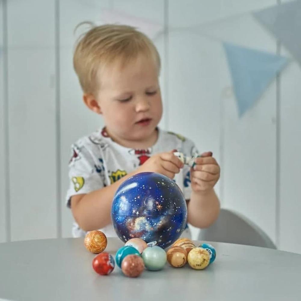 Drewniany zestaw planet w kuli, chłopiec przy zestawie