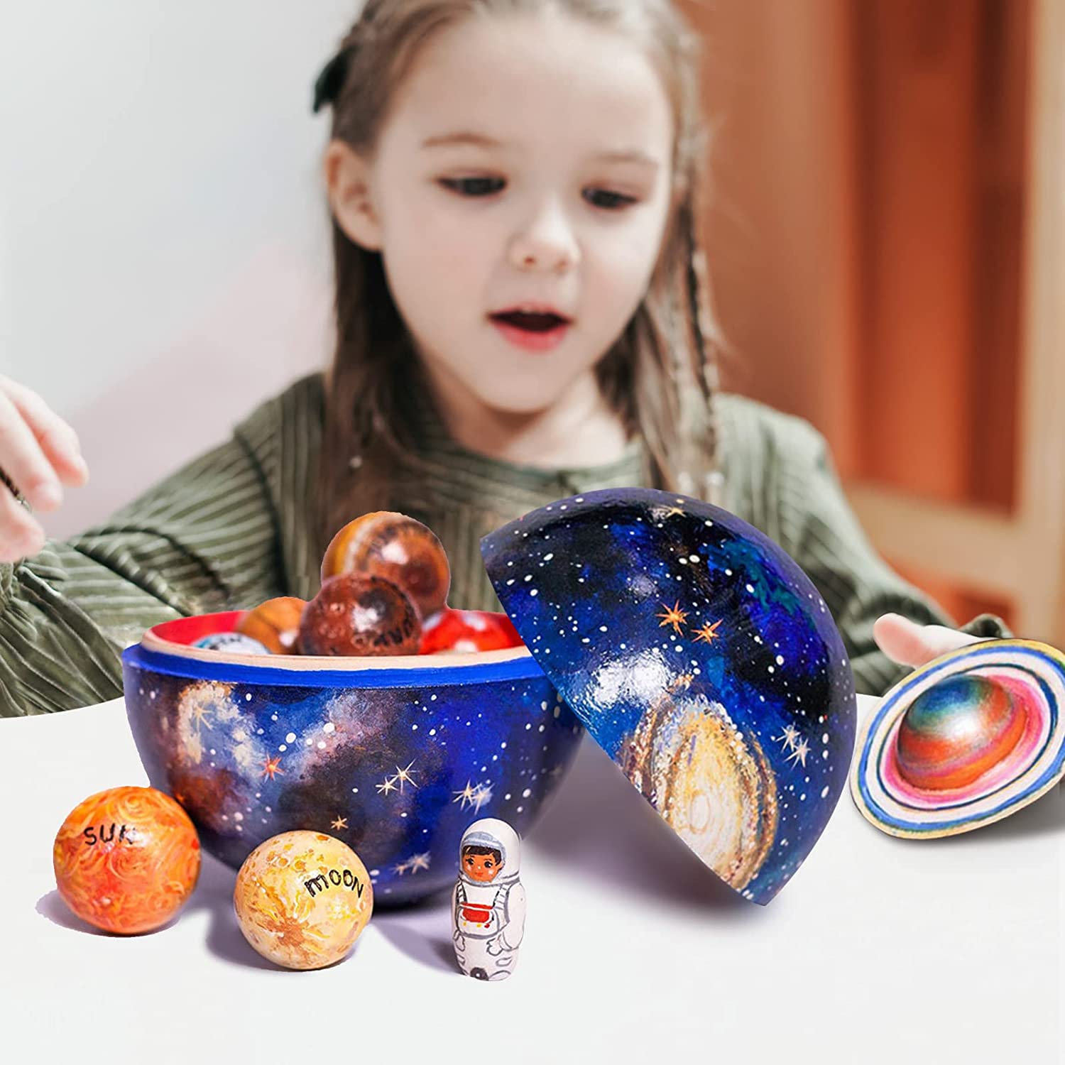 Drewniany zestaw planet w kuli, dziewczynka bawi się planetami